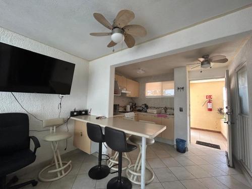 a kitchen with a table and chairs and a ceiling fan at Suite Villas Palmas Diamante in Acapulco
