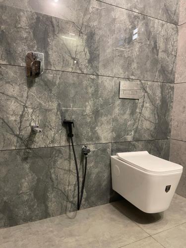 a bathroom with a toilet and a wall at Neev holiday homes in Vythiri