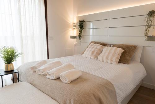 a bedroom with a white bed with three pillows on it at Casita Romántica con Suite y Bañera en la Sierra "Colladito de Alce" in Collado Hermoso