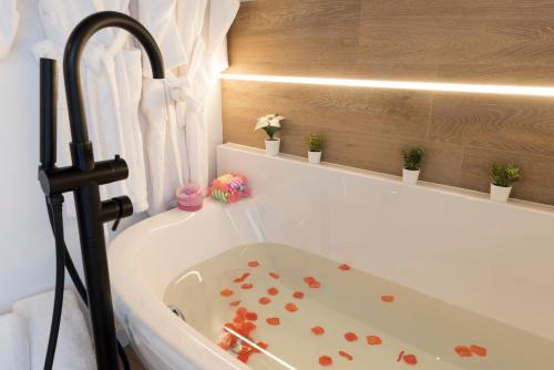 a bath tub with red hearts on the side of it at Casita Romántica con Suite y Bañera en la Sierra "Colladito de Alce" in Collado Hermoso