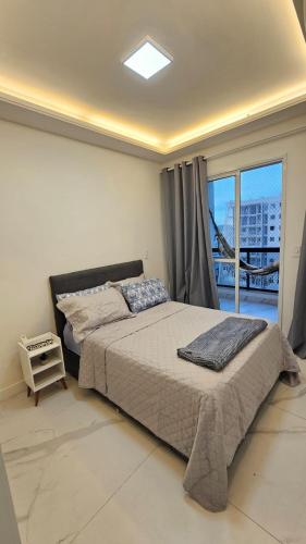 a bedroom with a large bed and a balcony at Apê Morabeza in Vila Velha