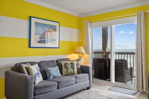 a living room with a couch and a view of the ocean at Beach, Please! Oceanfront, Balcony & Sunrise Views in North Topsail Beach