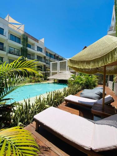 a resort with a swimming pool with beds and umbrellas at Bakal Luxury condos in Tulum
