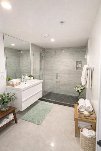a bathroom with a shower and a sink and a tub at CasaViva Loft - Modern 2BR with Garage Parking, In-Unit Washer Dryer & ADA Access - Walk to Hillcrest, 5 Min to Gaslamp & North Park in San Diego