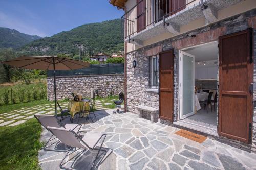 a patio with two chairs and an umbrella at Lenno Dolcelago in Lenno