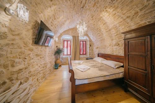 a bedroom with a bed in a stone wall at Alternative Medieval Villa in Kalamoti