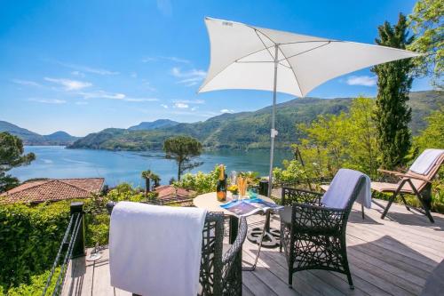 a table and chairs on a deck with a view of a lake at Morcote Magic View in Morcote