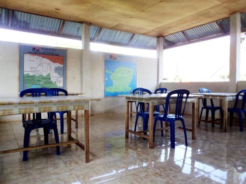 una stanza con tavoli e sedie e una mappa sul muro di Rinjani Inn a Sembalun Lawang