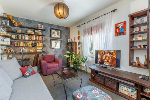 a living room with a couch and a tv at Cozy Home with Private Garden - Happy Rentals in Dražice