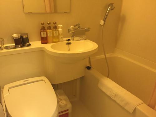 a small bathroom with a sink and a toilet at Dormy Inn Hiroshima in Hiroshima