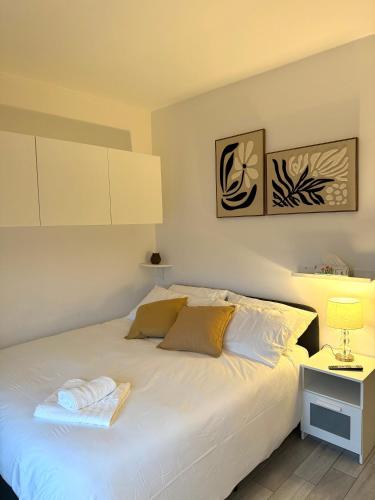 a bedroom with a white bed with a night stand at Pieno Centro in Basiglio