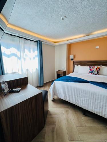 a hotel room with a bed and a desk at Suites del Jardín Principal in Guanajuato