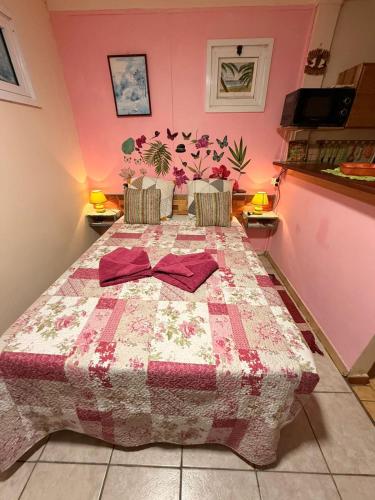 a bedroom with a bed with a quilt on it at GITE LE FILAO in Le Lorrain