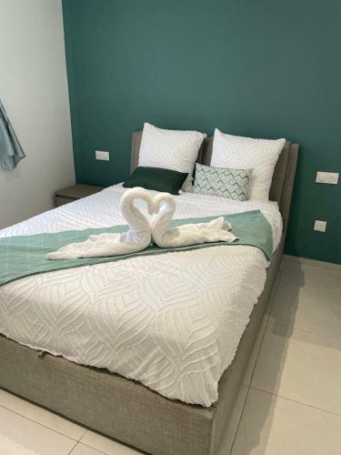 a large bed with two white towels on it at Studio Élégance in Cayenne