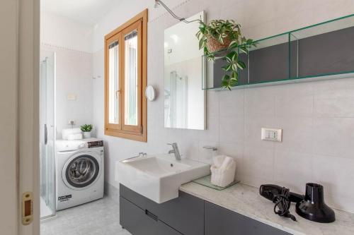 a bathroom with a sink and a washing machine at Apartment in Serravalle in Vittorio Veneto