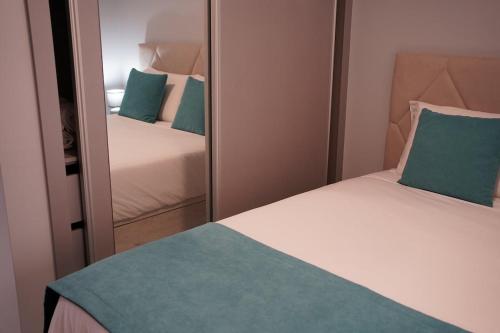 a bedroom with two beds and a mirror at Pauloldtown - Local experience w rooftop n jacuzzi in Paul do Mar