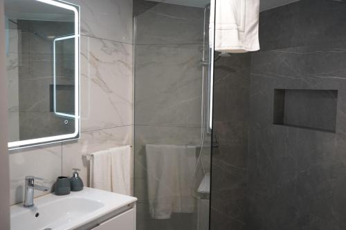 a bathroom with a shower and a sink and a mirror at Pauloldtown - Local experience w rooftop n jacuzzi in Paul do Mar