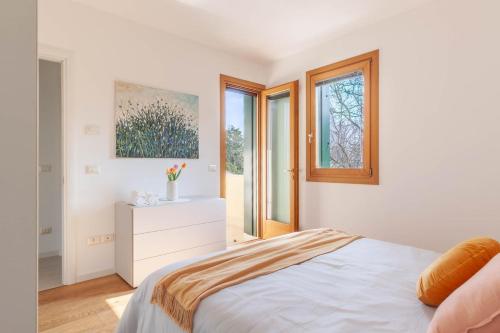 a white bedroom with a bed and a window at Apartment in Serravalle in Vittorio Veneto