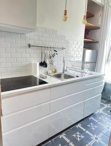 a white kitchen with a sink and a counter at Petit nid calme à 2 pas de Paris in Ivry-sur-Seine