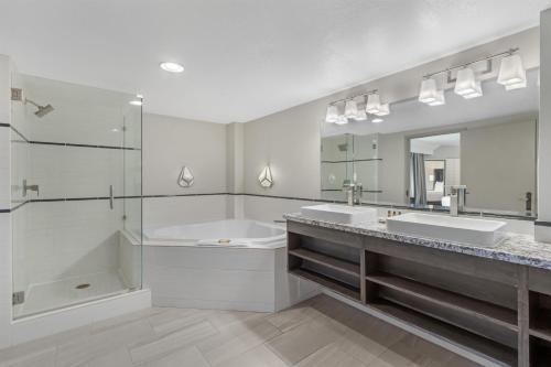 a bathroom with two sinks and a tub and a mirror at Best Western Plus Boomtown Casino Hotel in Verdi