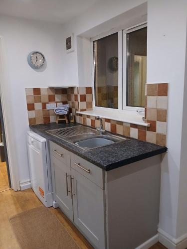 a small kitchen with a sink and a window at Modern Coastal Haven Family and Dog friendly in Burry Port
