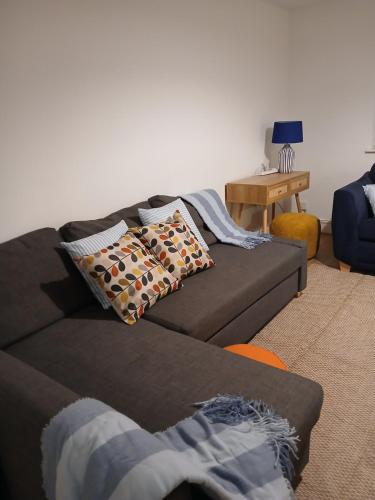 a living room with a brown couch with pillows at Modern Coastal Haven Family and Dog friendly in Burry Port