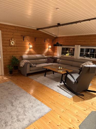 a living room with a couch and a table at Koselig hytte in Skillemo