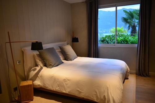 a bedroom with a bed with a large window at L'Orchidée in Sévrier