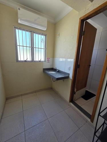 an empty room with a sink and a window at Hostel Araguaia in Goiânia