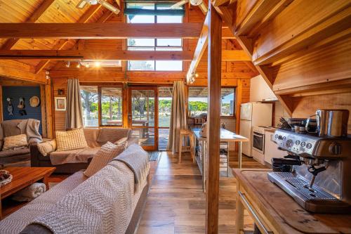 a living room with couches and a kitchen in a cabin at The Dunes Hideaway in Dolphin Sands