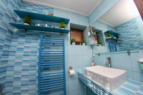 a bathroom with blue tiled walls and a sink at Hedonist Spa Jacuzzi Centar Free private parking in Sarajevo