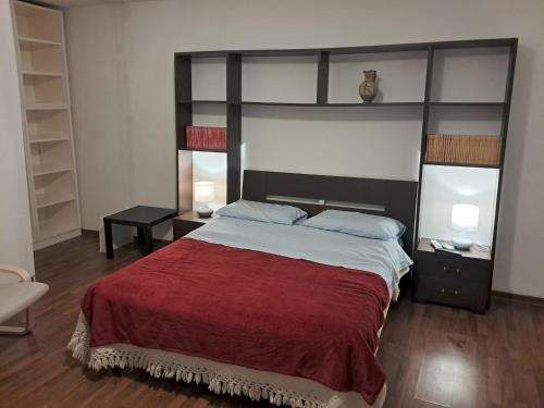 a bedroom with a large bed with a red blanket at L'edera in Tuscania