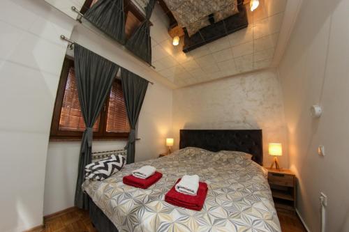 a bedroom with a bed with two red towels on it at Hedonist Spa Jacuzzi Centar Free private parking in Sarajevo