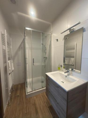 a bathroom with a glass shower and a sink at Hrochoťský mlyn in Hrochoť