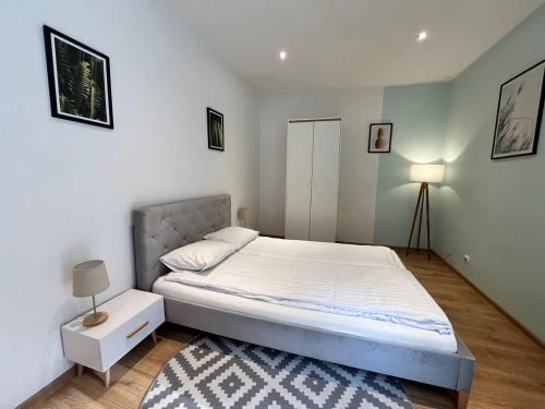 a bedroom with a bed and a nightstand and a bed sidx sidx sidx sidx at Spokojny Potok Sopot - AFRA GROUP in Sopot