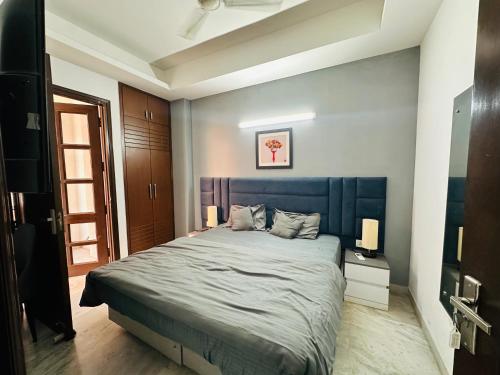 a bedroom with a large bed with a blue headboard at Remix stays in Gurgaon