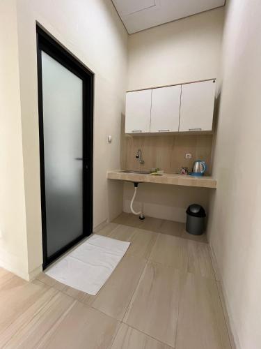 an empty kitchen with a large door in a room at Menata Villa Harmoni in Pakem