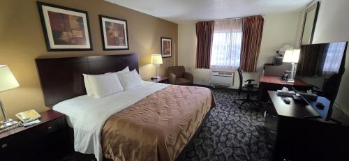 a hotel room with a bed and a desk at Quality Inn & Suites Eldridge Davenport North in Eldridge