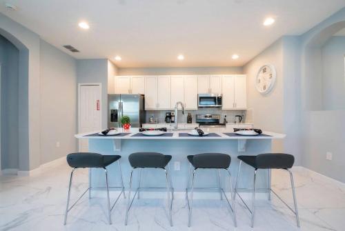 a kitchen with a large island with four bar stools at Cozy 4BR Villa w Private Pool Spa Near Disney in Kissimmee