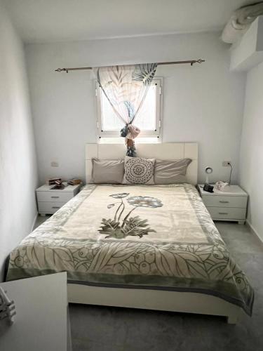 a bedroom with a large bed and a window at ain draham sejour 1 familles seulement in Aïn Draham