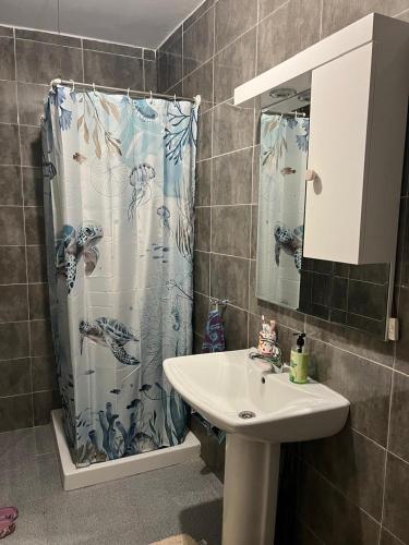 a bathroom with a sink and a shower curtain at ain draham sejour 1 familles seulement in Aïn Draham