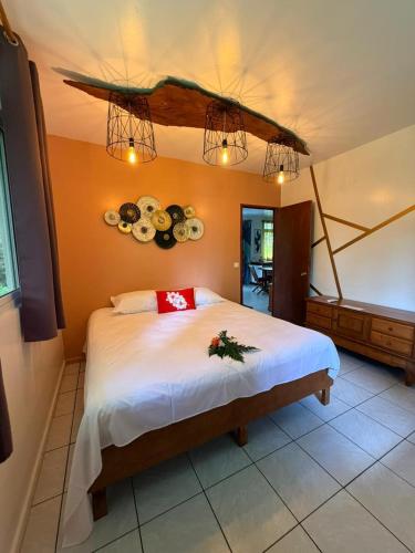 a bedroom with a large bed with plates on the wall at Plage privée - Vahine Ori Lodge in Raiatea