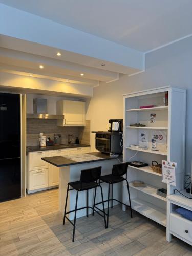 a kitchen with a counter and two bar stools at Vista Lago in Basiglio