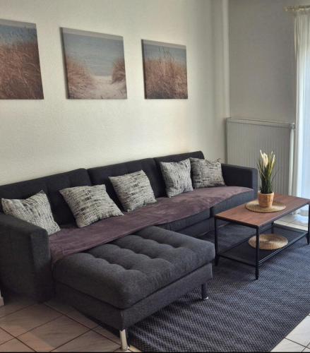 a living room with a couch and a table at Ferienhaus Wattgeflüster Neßmersiel in Neßmersiel