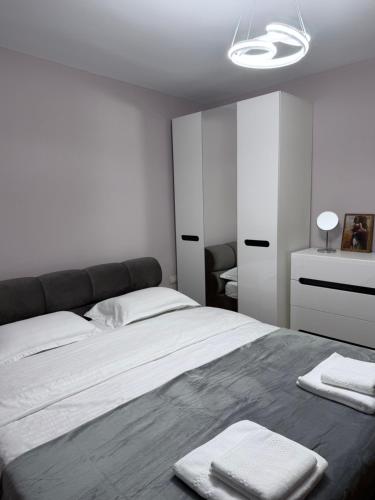 a bedroom with a bed with two towels on it at Trea Apartment in Tirana
