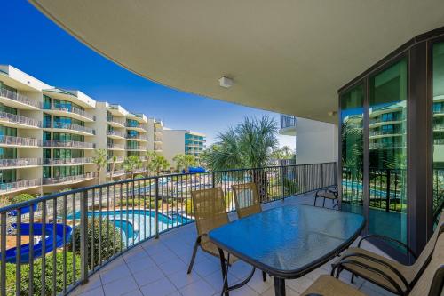 a balcony with a table and chairs and a pool at Phoenix on the Bay 1213 in Orange Beach