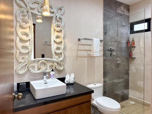 a bathroom with a sink and a mirror at Casa Daniela in Puerto Morelos