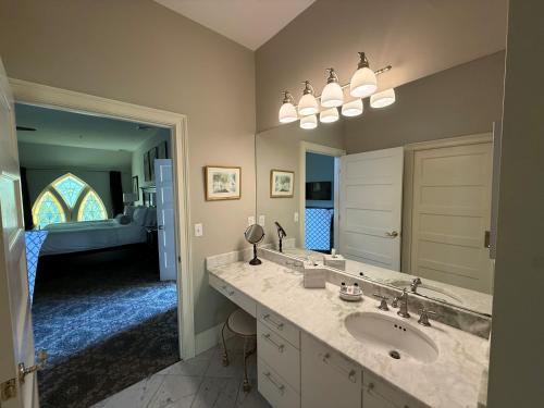 a bathroom with a sink and a large mirror at Belfry Inn and Bistro in Sandwich