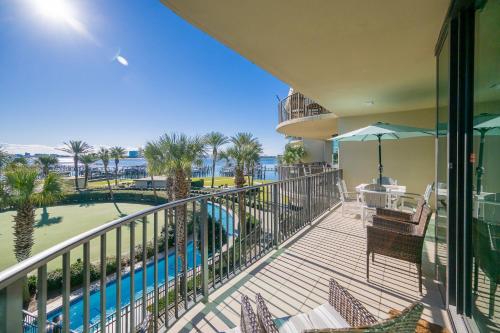 a balcony with a view of a pool and palm trees at Phoenix on the Bay 1206 in Orange Beach