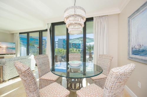 a dining room with a glass table and chairs at Phoenix on the Bay 1206 in Orange Beach